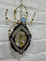 Black oval frame with gold Knicks Spider