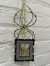 black square frame with green spider