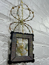 black square frame with green spider