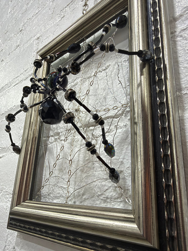 grey antique frame with black spider